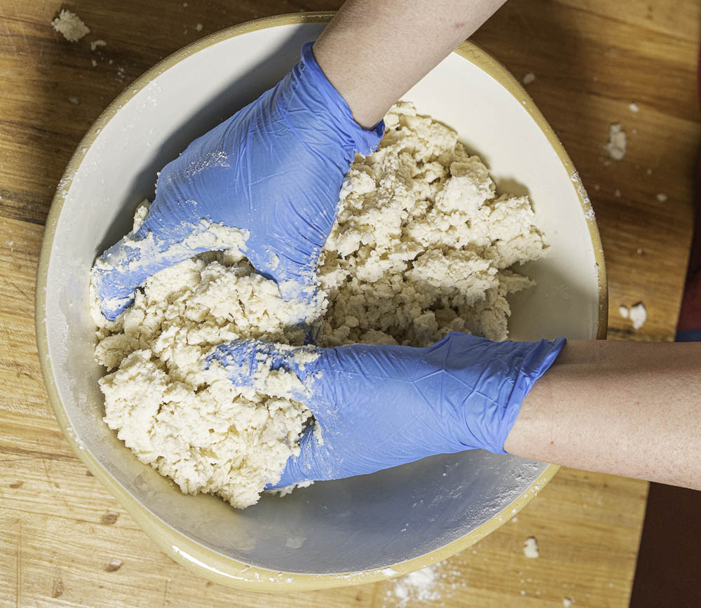 photo of a strawberry rhubarb pie hands mixing ingredients