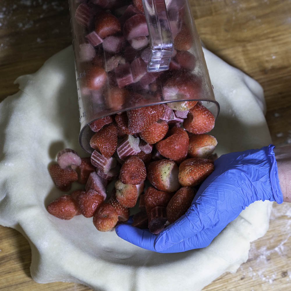 photo of a strawberry rhubarb pie adding frozen strawberries and rhubarb