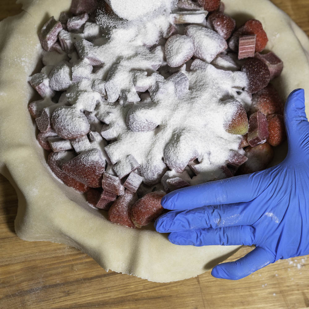 photo of a strawberry rhubarb pie adding sugar