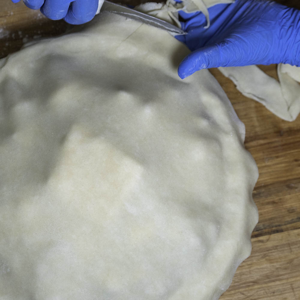 photo of a strawberry rhubarb pie crust being trimmed